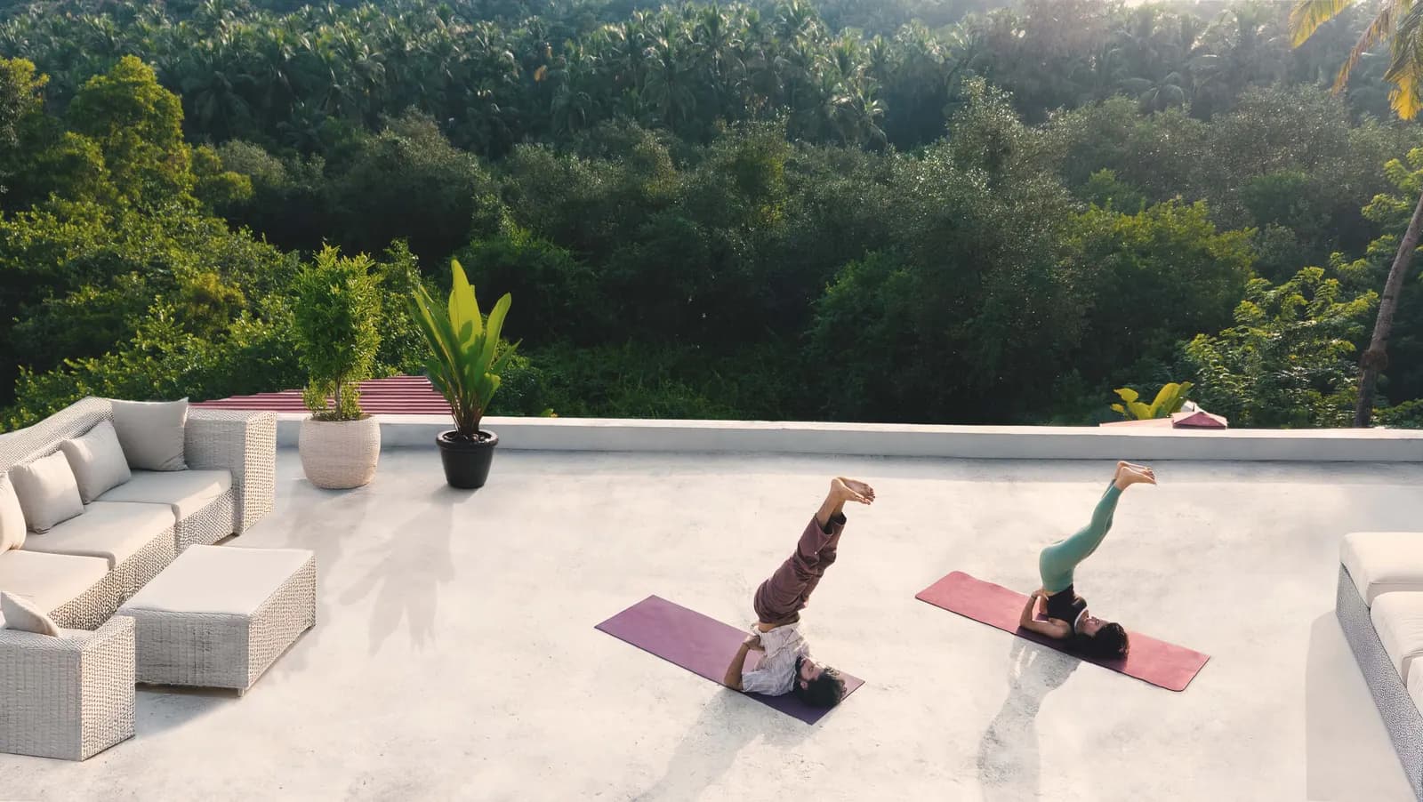Two people practising yoga on the rooftop terrace