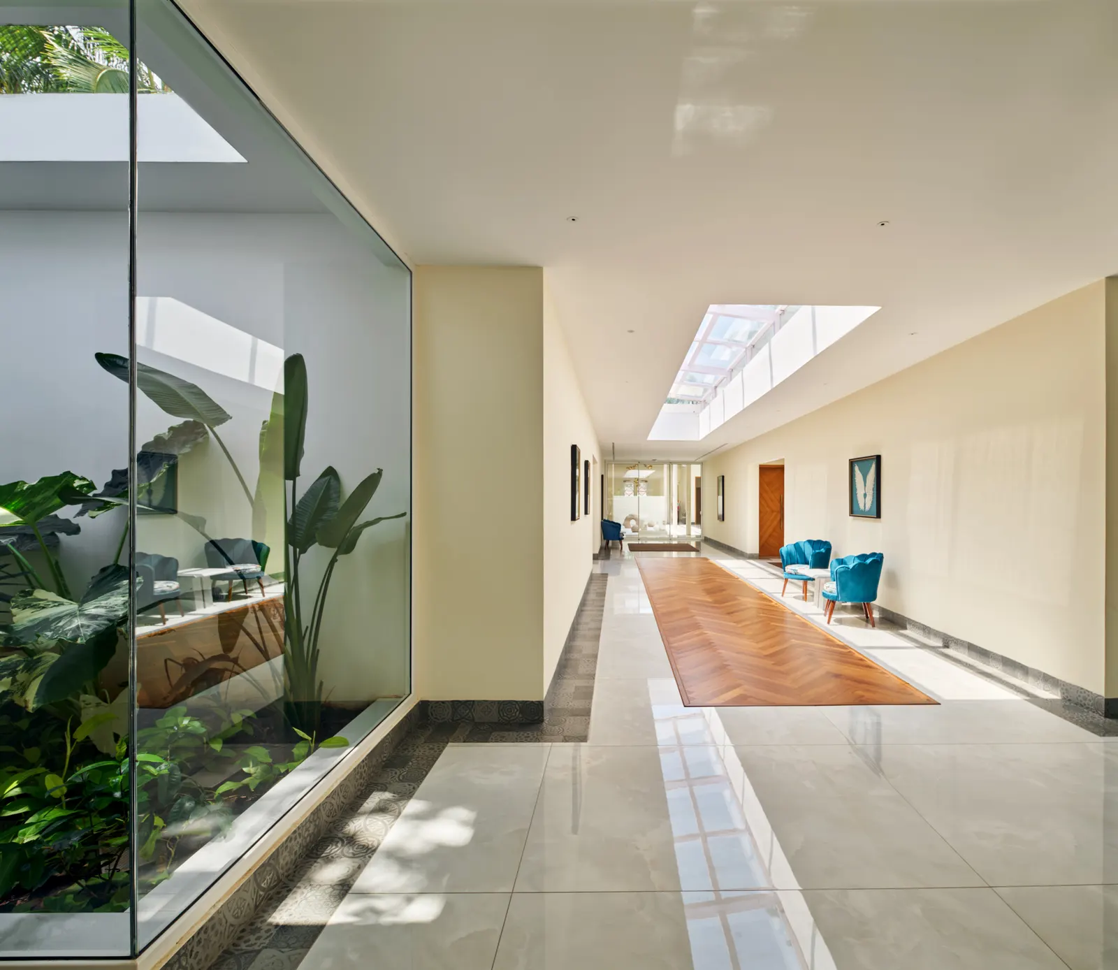 A sunlit corridor beside the planted glass courtyard