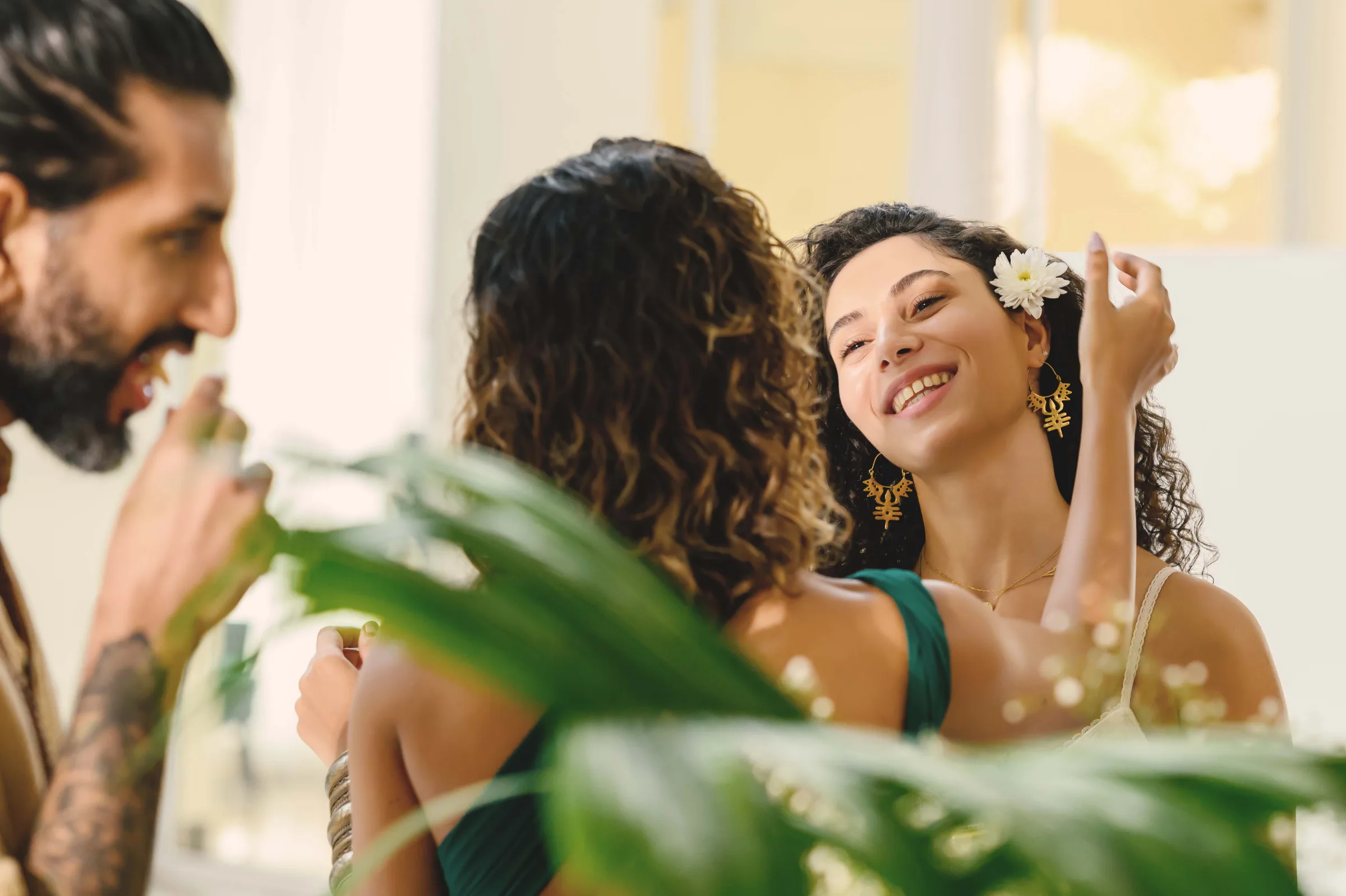 Drei Personen neben einer Tischdekoration mit Blumen